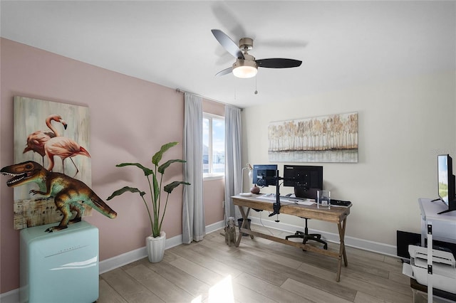 home office with wood finished floors, a ceiling fan, and baseboards