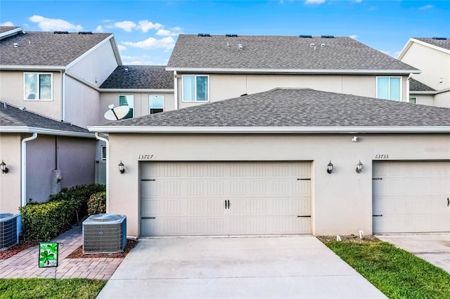 garage with driveway and central AC unit