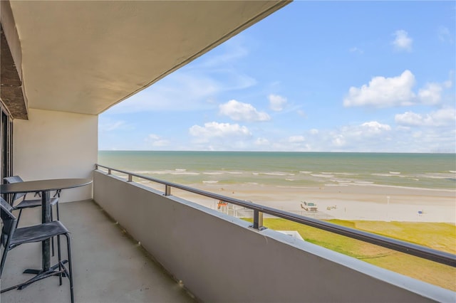 balcony featuring a beach view and a water view