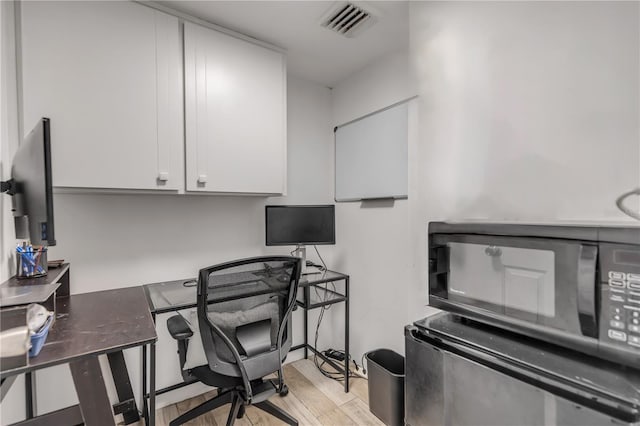 office featuring light wood finished floors and visible vents