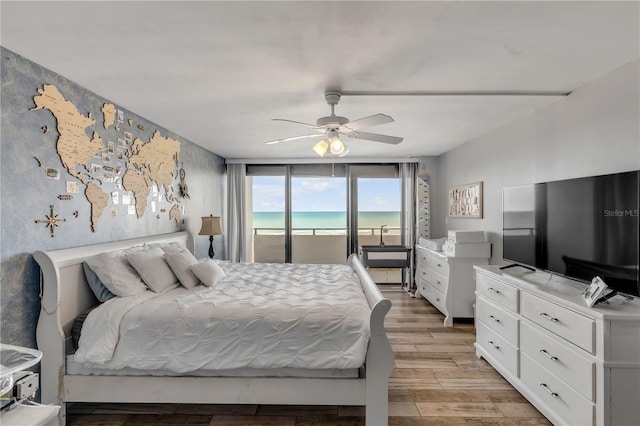 bedroom with wallpapered walls, access to outside, ceiling fan, and wood finish floors