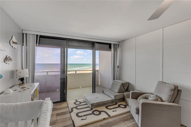 interior space with a beach view, wood finish floors, and a water view