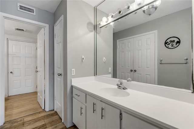 bathroom with visible vents, wood finished floors, and vanity