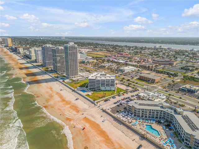 drone / aerial view featuring a view of city, a beach view, and a water view