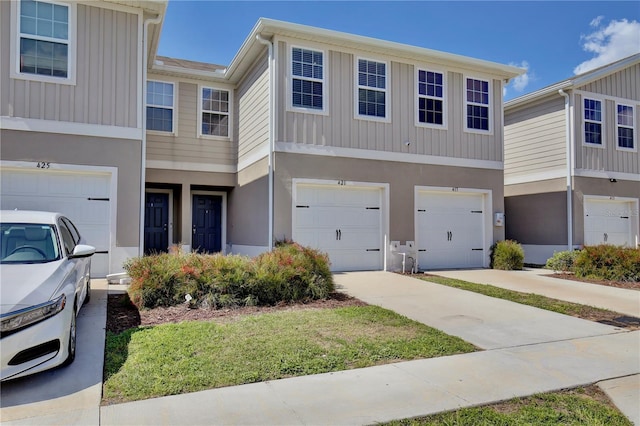 multi unit property featuring an attached garage and driveway