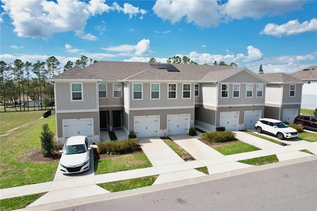 421 Sedgewick Dr, Davenport, FL 33837 - view of property featuring an attached garage, driveway, roof mounted solar panels, and roof with shingles