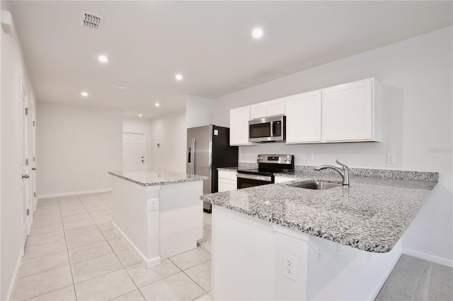 421 Sedgewick Dr, Davenport, FL 33837 - kitchen featuring stainless steel appliances, a sink, a center island, baseboards, and light stone counters