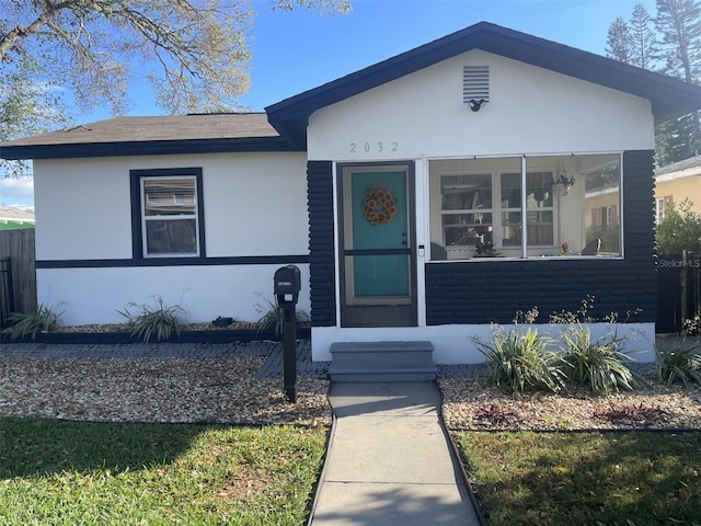 view of front of property featuring fence and stucco siding