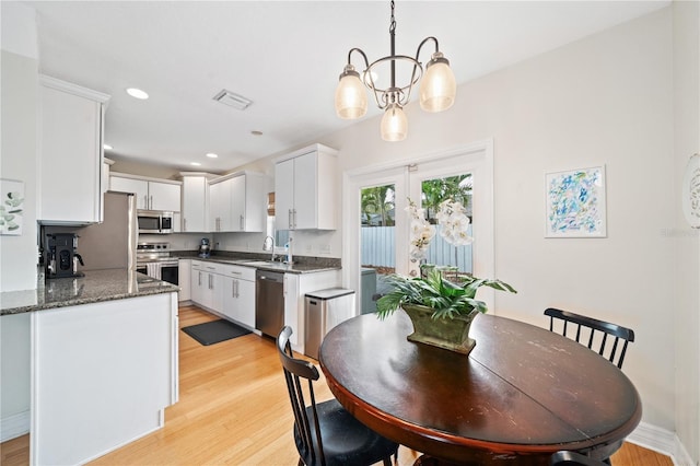 dining room featuring light wood finished floors, recessed lighting, visible vents, a chandelier, and baseboards