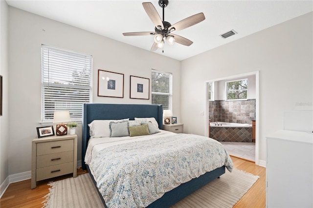 bedroom with multiple windows, light wood-type flooring, visible vents, and baseboards