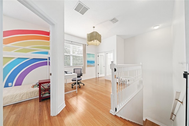 interior space with light wood-style flooring, visible vents, and baseboards