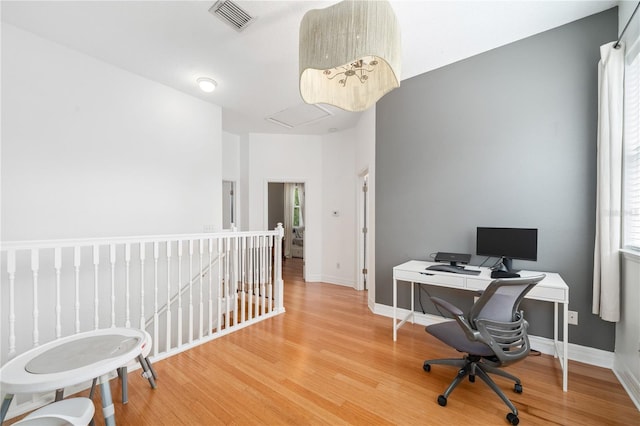 office space with visible vents, baseboards, and wood finished floors