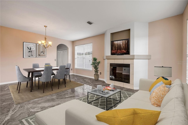 living room with baseboards, visible vents, a tile fireplace, marble finish floor, and a chandelier