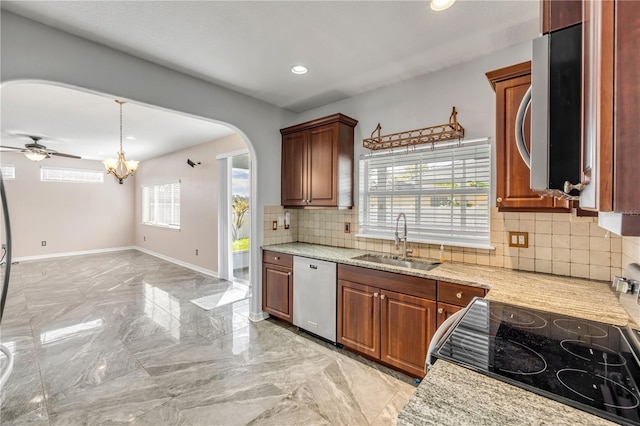 kitchen featuring arched walkways, a sink, baseboards, marble finish floor, and appliances with stainless steel finishes