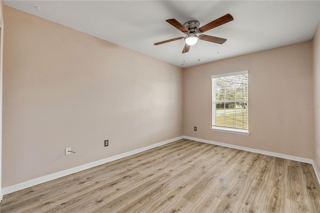 unfurnished room featuring light wood-type flooring, a ceiling fan, and baseboards