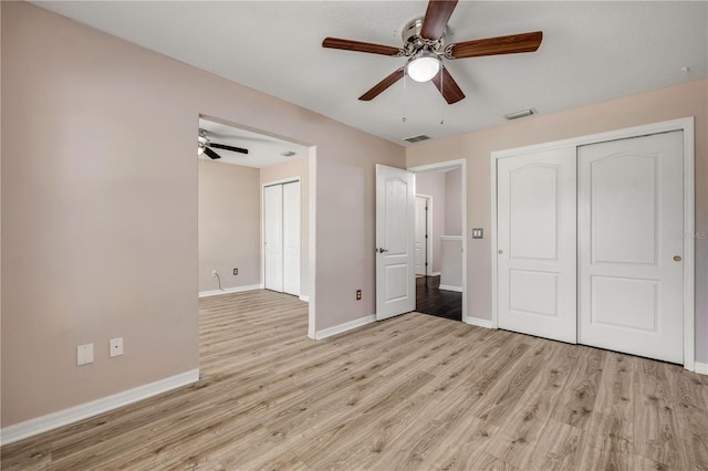 unfurnished bedroom featuring light wood-type flooring, baseboards, visible vents, and ceiling fan