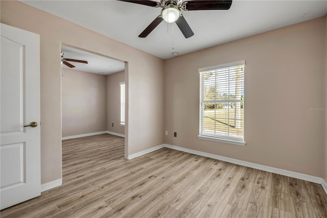 spare room featuring light wood-type flooring and baseboards