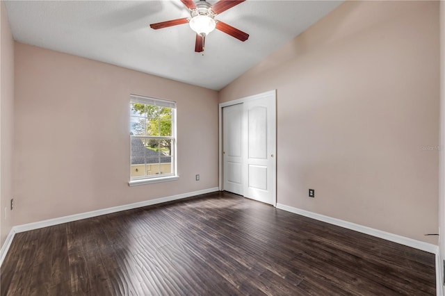 unfurnished bedroom with baseboards, a ceiling fan, lofted ceiling, dark wood-style flooring, and a closet