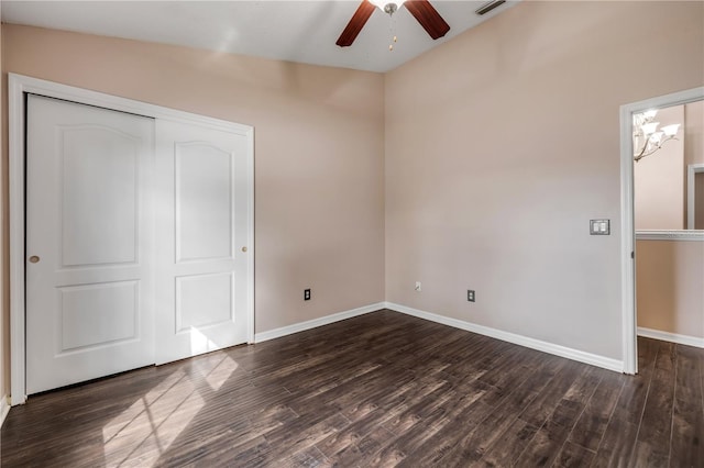 unfurnished bedroom with dark wood-style floors, visible vents, baseboards, and a closet