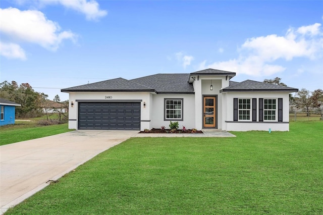 prairie-style house featuring a front yard, concrete driveway, an attached garage, and stucco siding