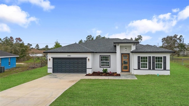 prairie-style home featuring driveway, an attached garage, central air condition unit, a front lawn, and stucco siding