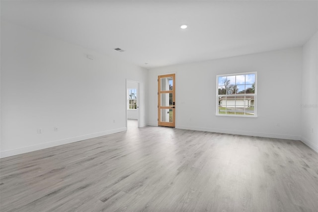 empty room featuring recessed lighting, baseboards, visible vents, and light wood finished floors