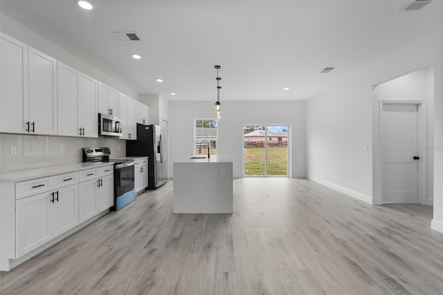 kitchen featuring appliances with stainless steel finishes, backsplash, a sink, and white cabinets