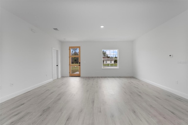 spare room with visible vents, light wood-style flooring, and baseboards