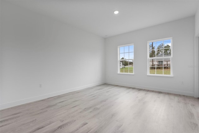 unfurnished room with light wood-style floors, recessed lighting, and baseboards