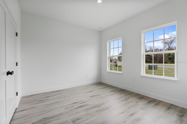 empty room featuring light wood-type flooring and baseboards