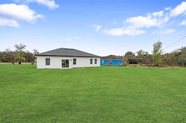 rear view of house featuring a yard