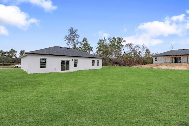 rear view of house featuring a yard