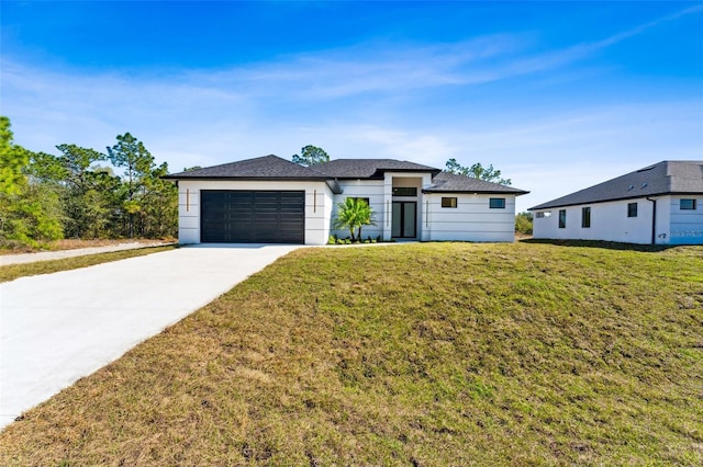 view of front of home featuring a garage, a front lawn, and concrete driveway