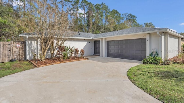 ranch-style home featuring an attached garage, fence, concrete driveway, and stucco siding