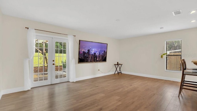 interior space featuring baseboards, visible vents, wood finished floors, french doors, and recessed lighting