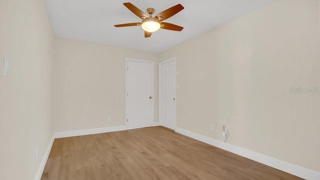 spare room with light wood-style floors, baseboards, and a ceiling fan