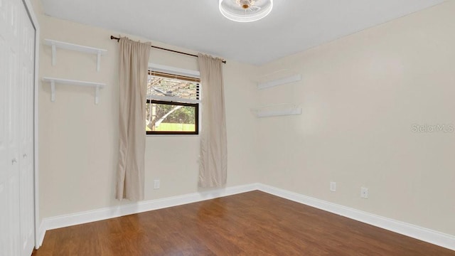 unfurnished room featuring dark wood finished floors and baseboards