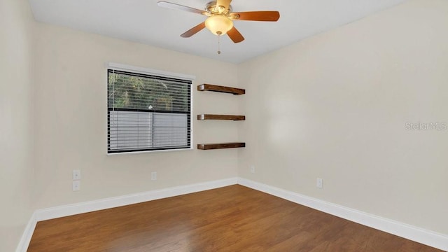 empty room featuring wood finished floors, a ceiling fan, and baseboards