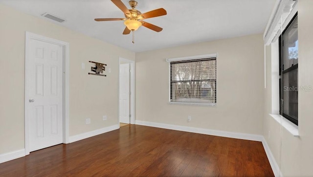 spare room featuring visible vents, ceiling fan, baseboards, and wood finished floors