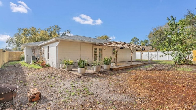 back of house featuring a fenced backyard, a pergola, and french doors