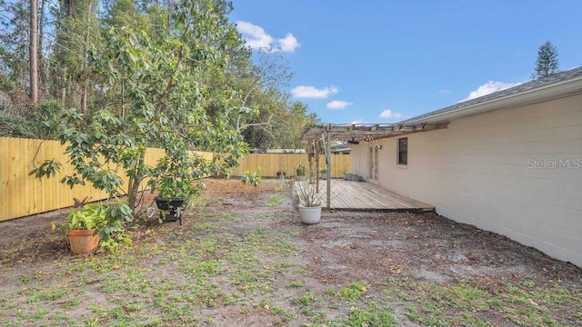 view of yard with a fenced backyard and a wooden deck