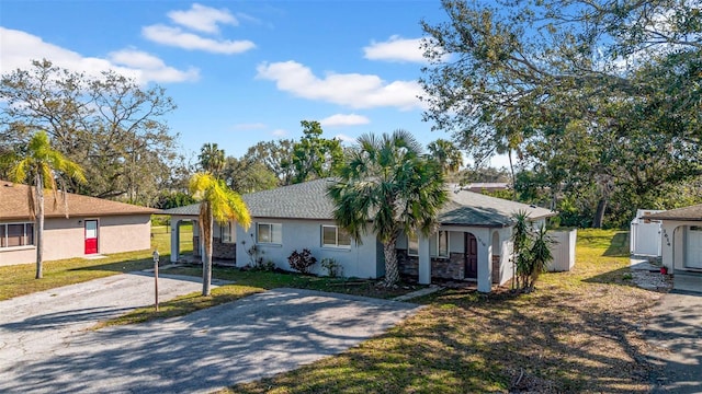 ranch-style house with driveway, a front lawn, and stucco siding