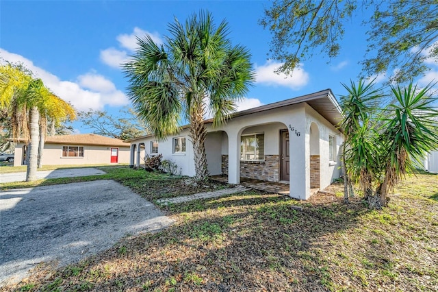 ranch-style home with a front yard and stucco siding