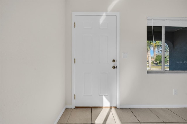 entryway with light tile patterned flooring and baseboards