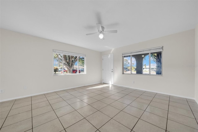 spare room featuring ceiling fan and baseboards