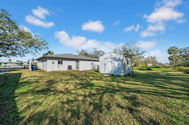 back of house featuring a storage shed, a lawn, and an outdoor structure