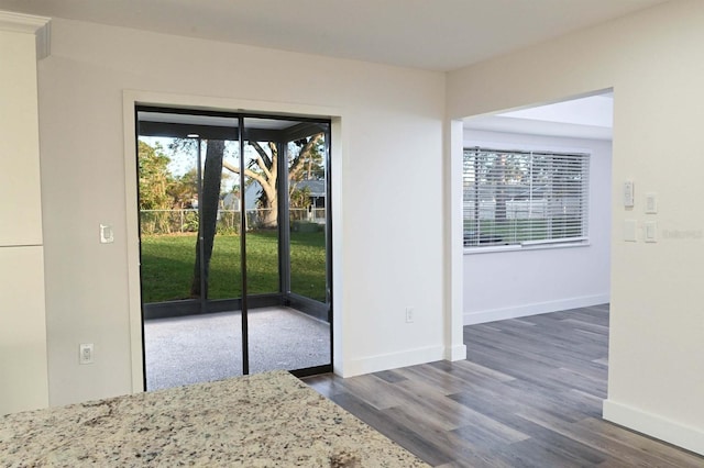 doorway to outside with baseboards and wood finished floors