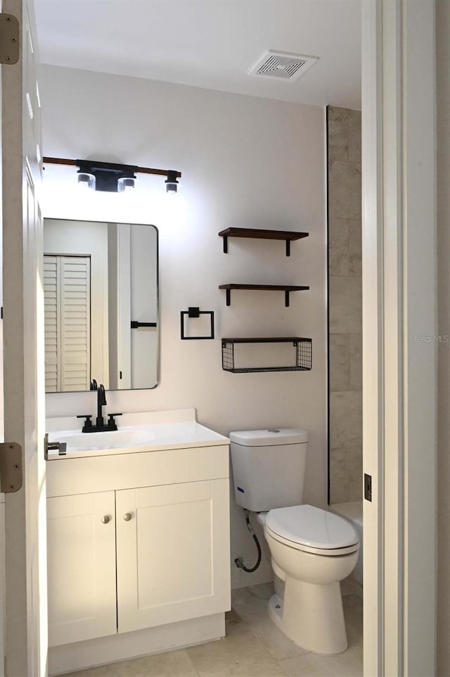 bathroom with visible vents, vanity, toilet, and walk in shower