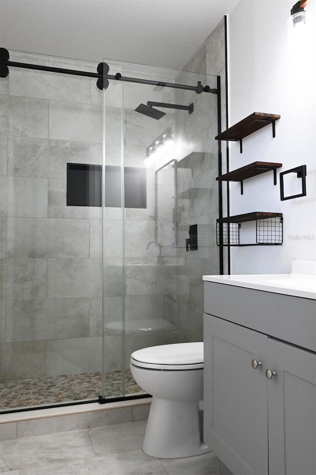 full bath with toilet, a shower stall, and vanity