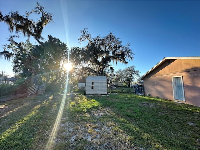 view of yard with a storage unit, an outdoor structure, and fence